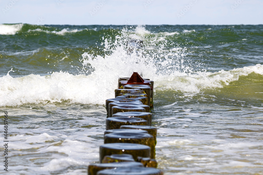 Landscapes of Poland. Breakwater at Baltic sea. Wavy water.