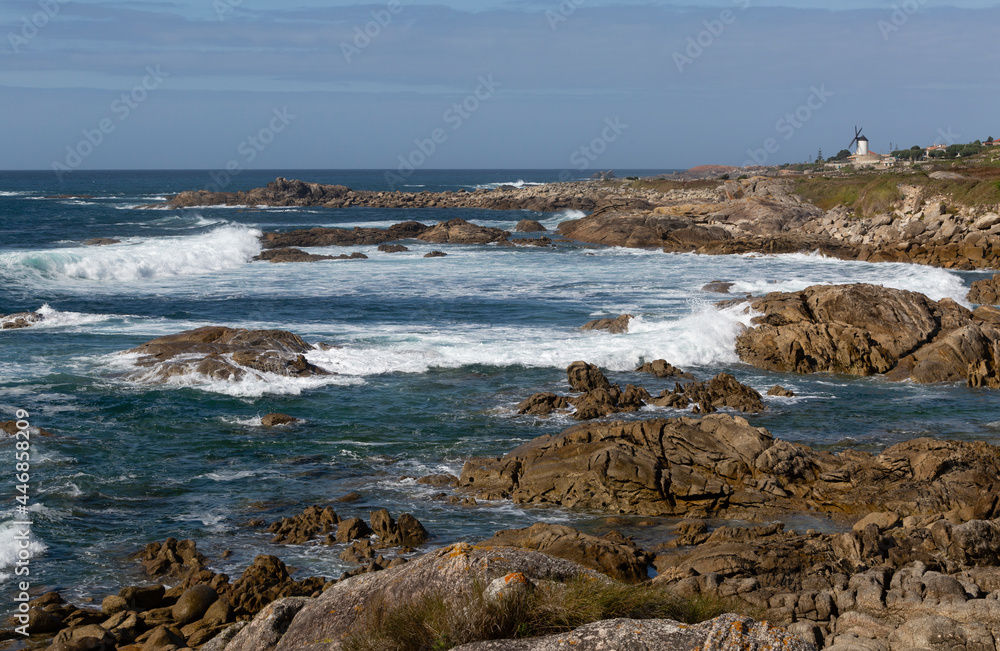 Vista de la costa de Oia con el océano Atlántico y un molino de viento.