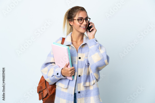 Young student woman isolated on white background keeping a conversation with the mobile phone