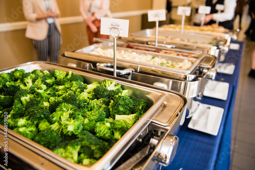 Buffet style trays with broccoli at an event