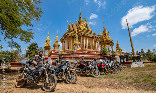 group of friends posing with motorcycle at temple in Cambodia photo