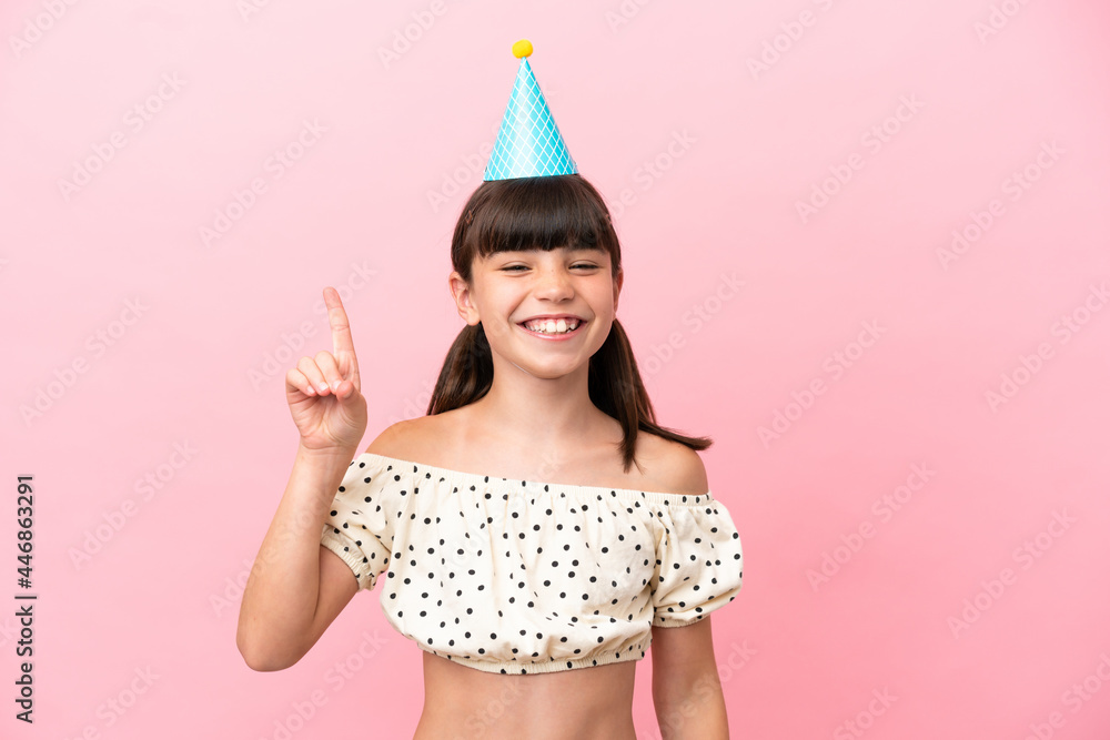Little caucasian kid with birthday hat isolated on pink background pointing up a great idea Little caucasian kid with birthday hat isolated on pink background pointing up a great idea