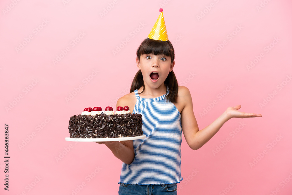 Little caucasian kid holding birthday cake isolated in pink background ...