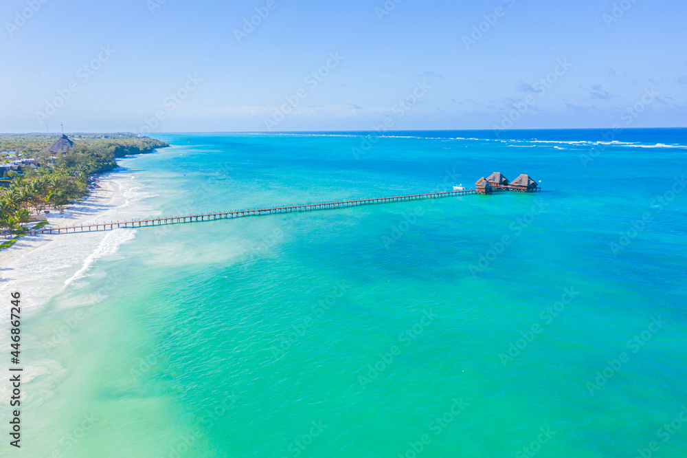 Fototapeta premium Aerial shot of the Stilt hut with palm thatch roof washed with t