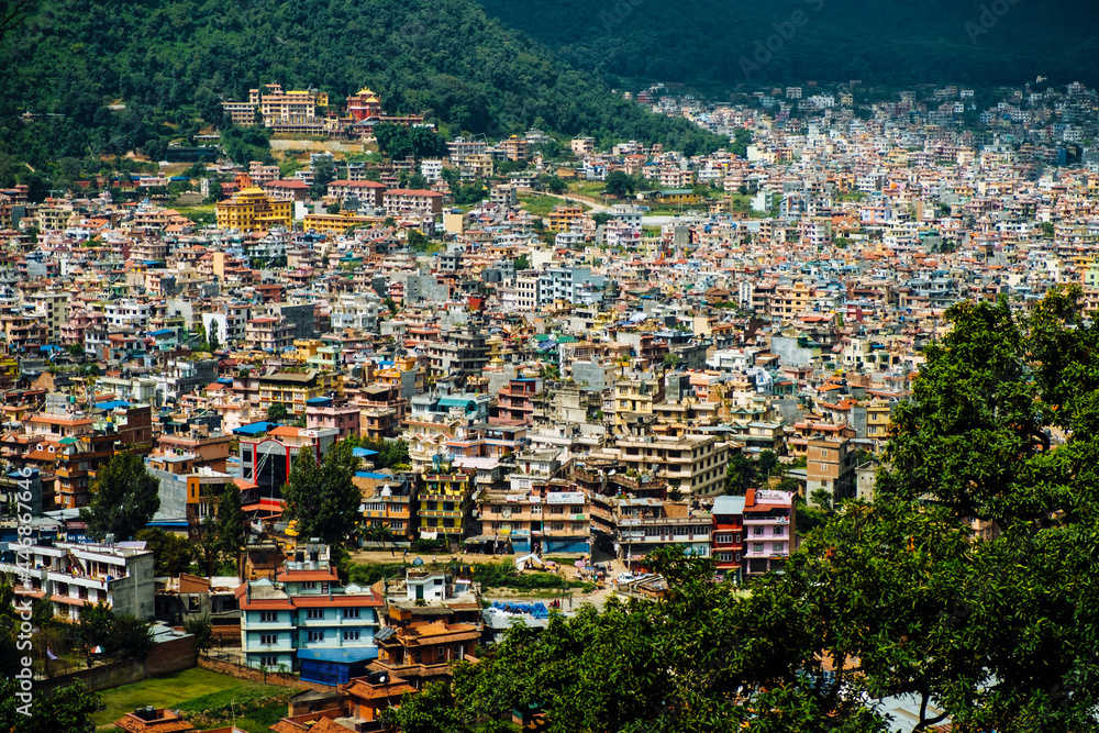 Obraz premium Colourful cityscape infrastructure housing of Kathmandu against mountains in Nepal during early morning light.