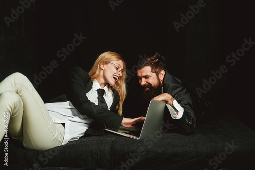 Happy business colleagues using laptop. Overjoyed couple look at laptop screen, excited happy young husband and wife read good news.