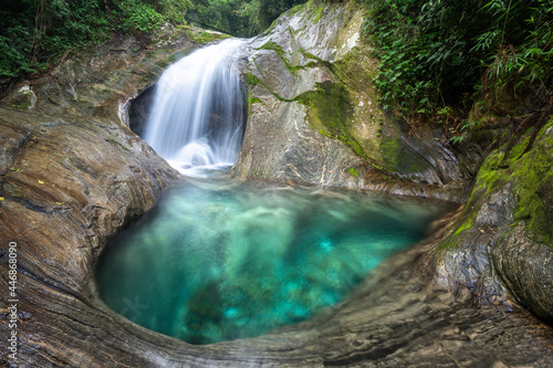 Beautiful green rainforest waterfall with crystal clear water pool photo