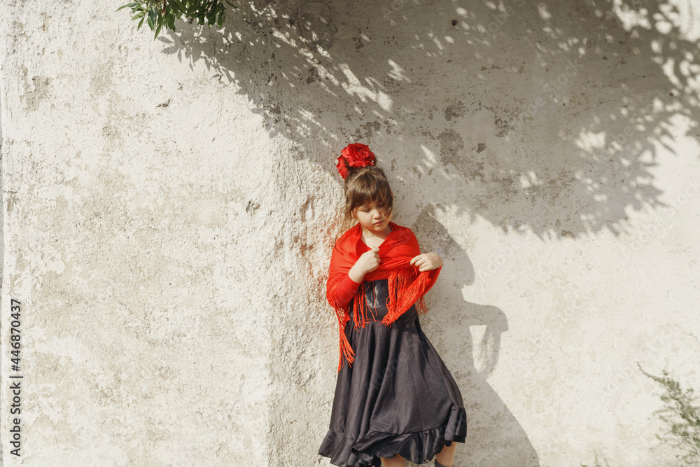 Little girl standing against white wall