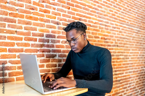 young african man working from his laptop photo