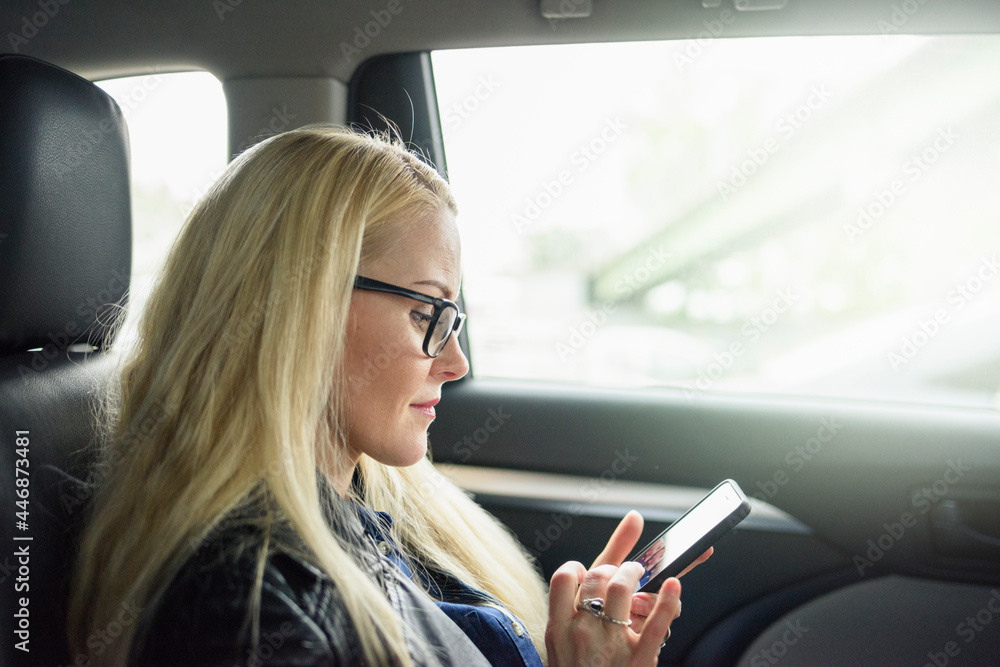 Calm woman using smartphone in car seat Calm woman using smartphone in car seat