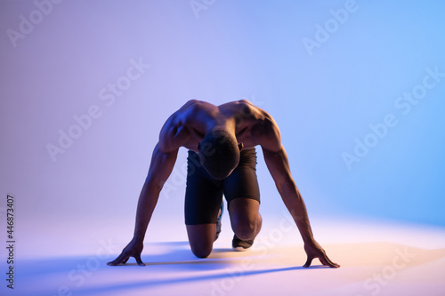 Black male runner standing in crouch start position photo