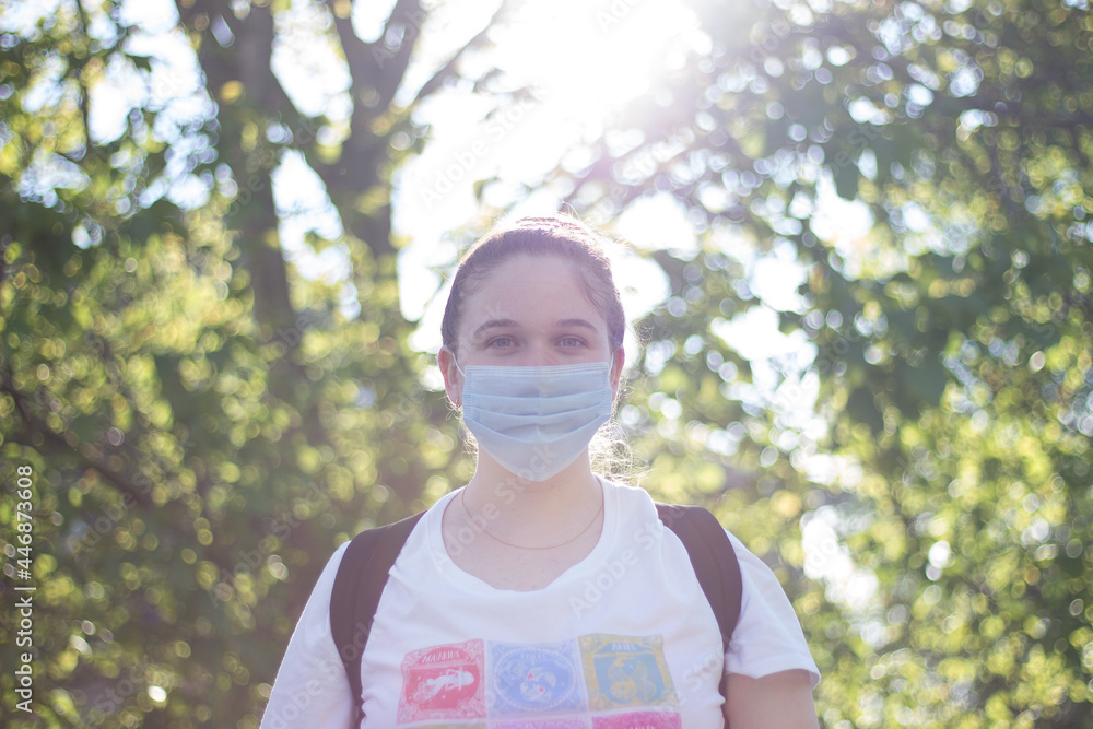 girl in a mask in sunny weather on the street girl in a mask in sunny weather on the street