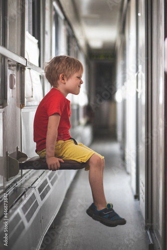 naughty child in corridor of train car. photo