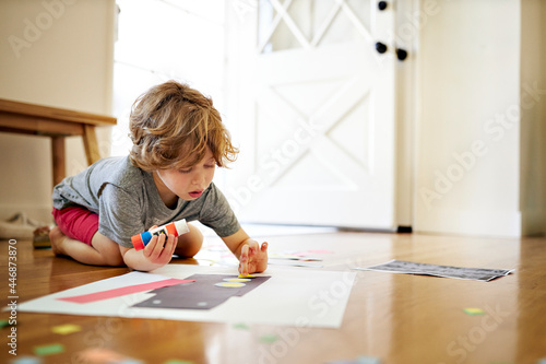 Boy holding glue while making paper art at home photo