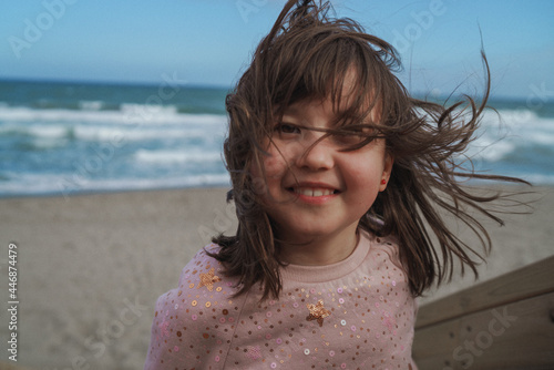 Girl against blue sky and ocean shore photo