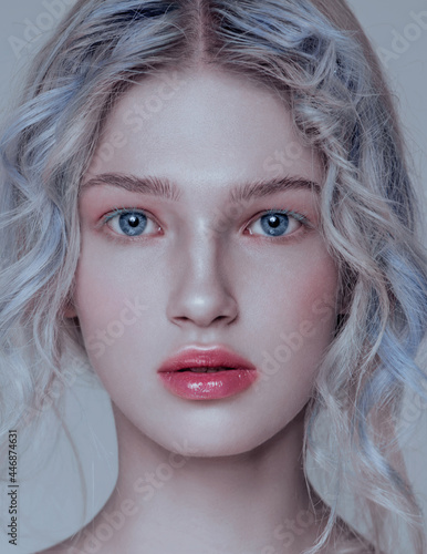 Beautiful woman portrait with glitter on face, silver white hair and wet skin and glitterr hands, blue headband and blue nails. Baby face photo