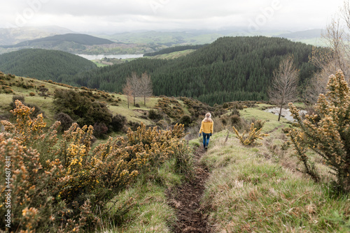 Tween in yellow sweater hiking on path in New Zealand photo