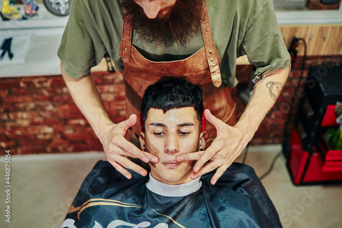 A young man in the barbershop getting a moustache massage. photo