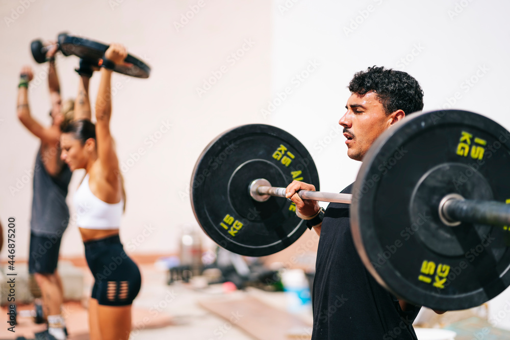 A group of sporty friends perform different exercise routines outdoors A group of sporty friends perform different exercise routines outdoors