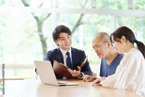 パソコン画面を見ならが説明を受ける高齢者	