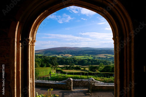 Amaizing view trough the open window. Open window of church with scenic view on green landscape of green fields.  Rolling landscape visible through window frame. Somerset  England.