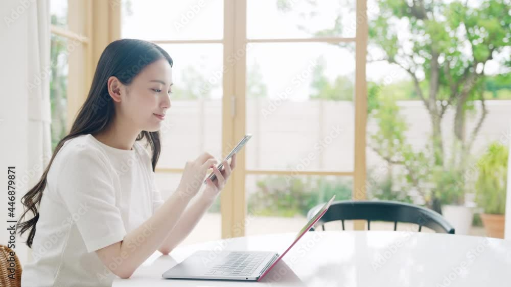 部屋でパソコンとスマホを使う女性 リモートワーク テレワーク 部屋でパソコンとスマホを使う女性 リモートワーク テレワーク