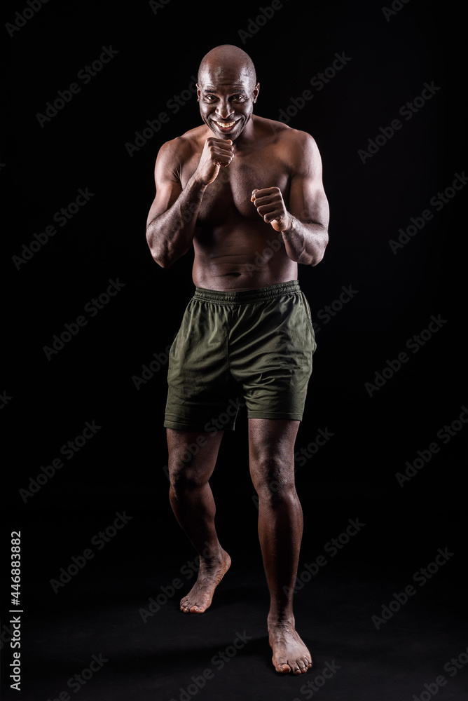 Muscular adult male smiling standing in defensive boxing pose