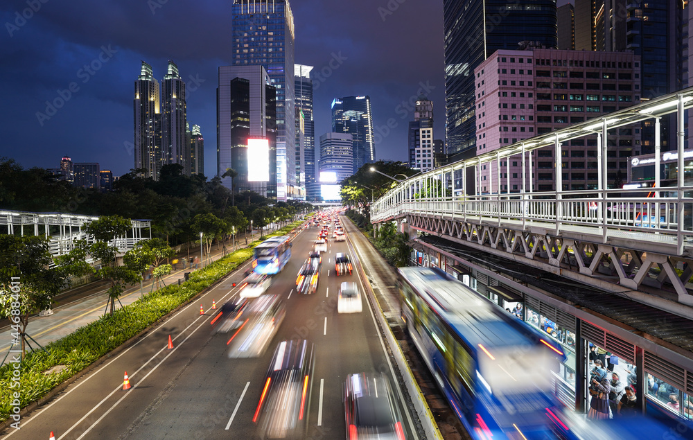 Traffic captured with blurred motion is rushing on the Jakarta main business and financial district at dusk in the modern Indonesia capital city