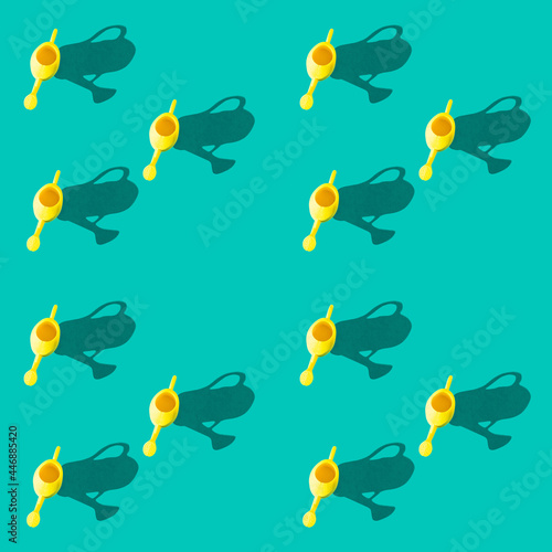 Photo in the form of a seamless pattern. Yellow watering can for watering flowers with shadows on a colored turquoise background. High quality photo