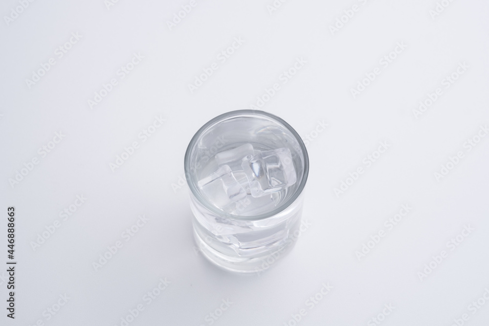 Transparent glass mug and ice cubes on a white background Transparent glass mug and ice cubes on a white background
