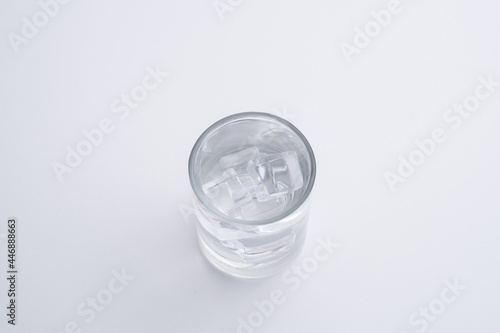 Transparent glass mug and ice cubes on a white background