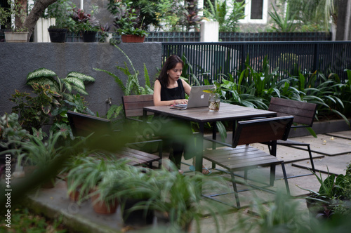Portrait of a serious businesswoman using laptop in the home garden © Saelanlerez