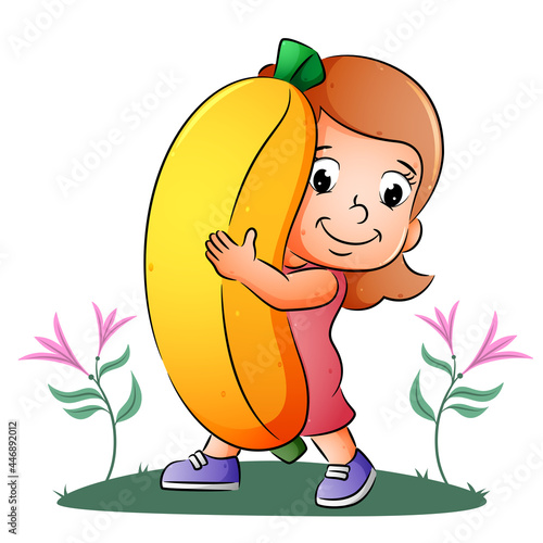 The girl is holding and showing the big bright banana