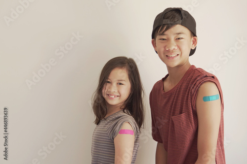 Fototapete Mixed Asian young girl and teen boy showing their arms with blue bandage after g