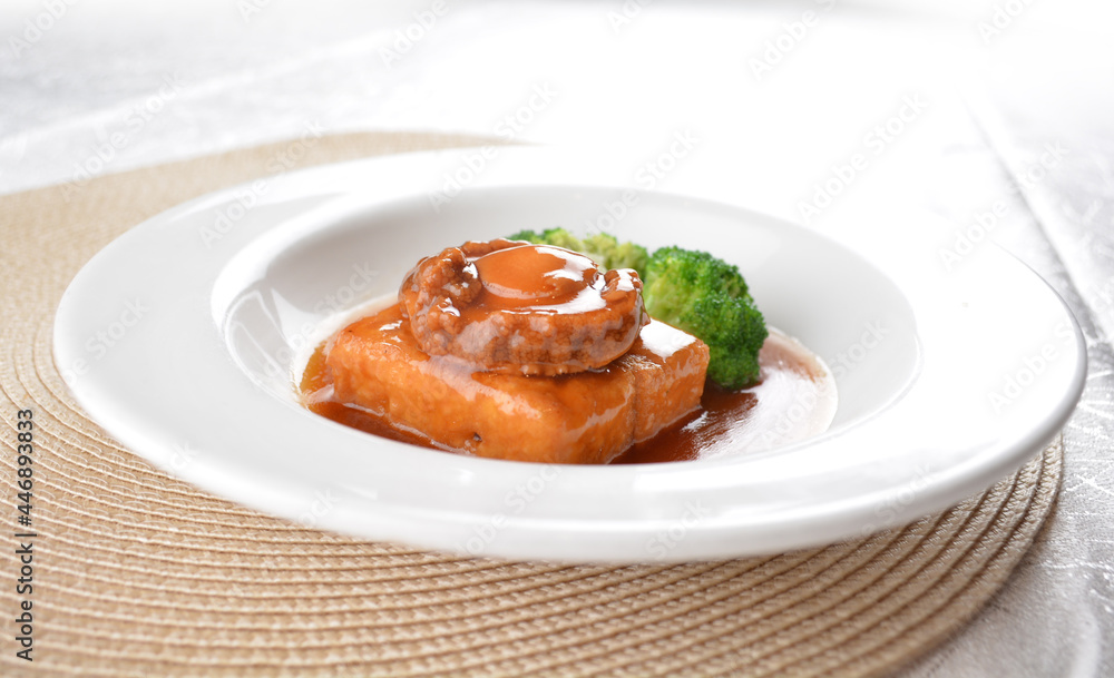 braised whole big abalone with bean curd tofu and broccoli in chef premium oyster sauce in white background asian halal seafood menu