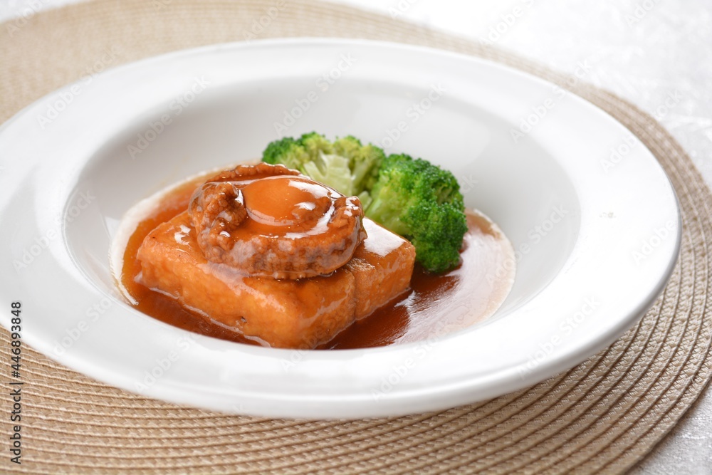 braised whole big abalone with bean curd tofu and broccoli in chef premium oyster sauce in white background asian halal seafood menu braised whole big abalone with bean curd tofu and broccoli in chef premium oyster sauce in white background asian halal seafood menu