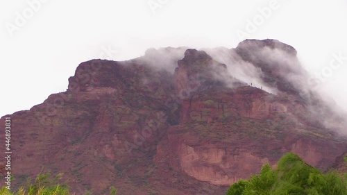 close up of red rock mountain with moving clouds during monsoon season  located between the Arizona beeline highway and salt river