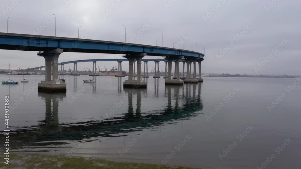 Reflection Of Coronado Bridge On The Water Of San Diego Bay During Cloudy Weather In California, USA. ascending drone shot Reflection Of Coronado Bridge On The Water Of San Diego Bay During Cloudy Weather In California, USA. ascending drone shot