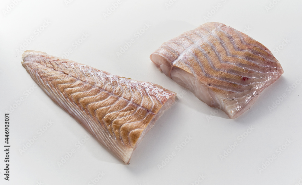 Raw cut fish fillet on white table