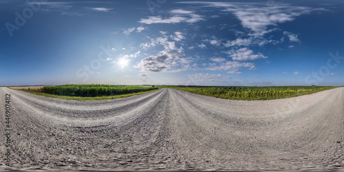 no traffic white sand gravel road among fields with cloudy sky in equirectangular projection, VR AR content. Full spherical seamless hdri panorama 360 degrees angle view