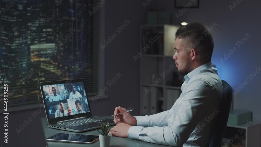 Director providing online conference with multiracial doctors of the city. Working in the evening with skyscrapers in the background. Director providing online conference with multiracial doctors of the city. Working in the evening with skyscrapers in the background.