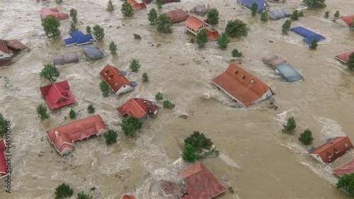 A huge natural disaster shot from the aerial top view—Flood swallows the town, countryside houses are destroyed by the heavy water and collapsed.  photo
