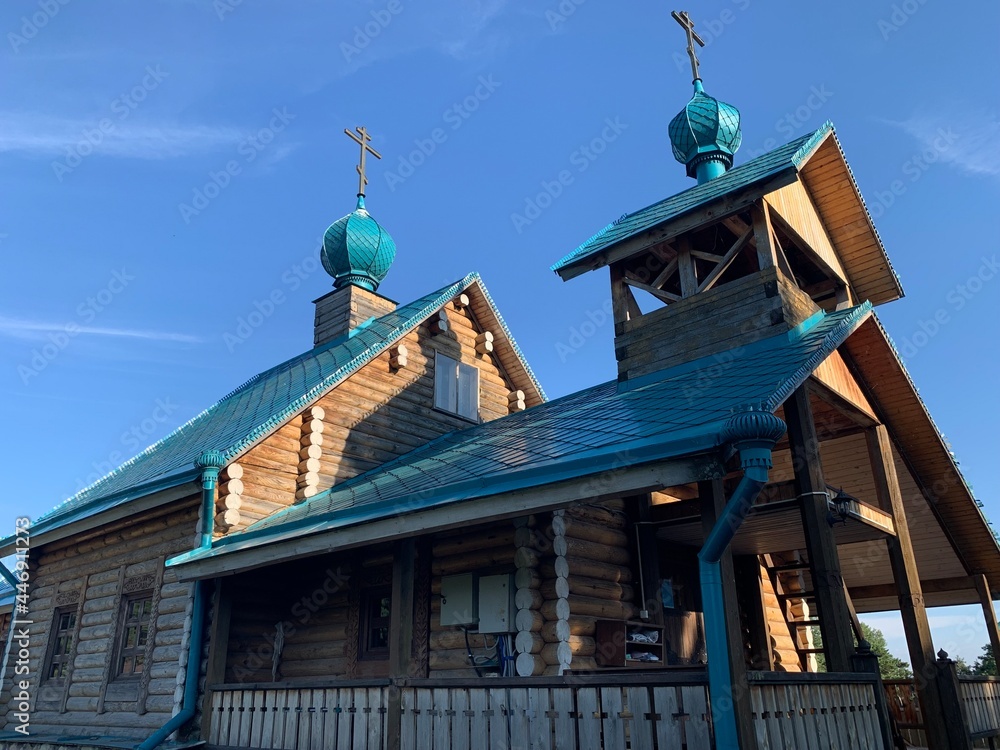Wooden orthodox church against a blue sky in summer on a sunny day.
