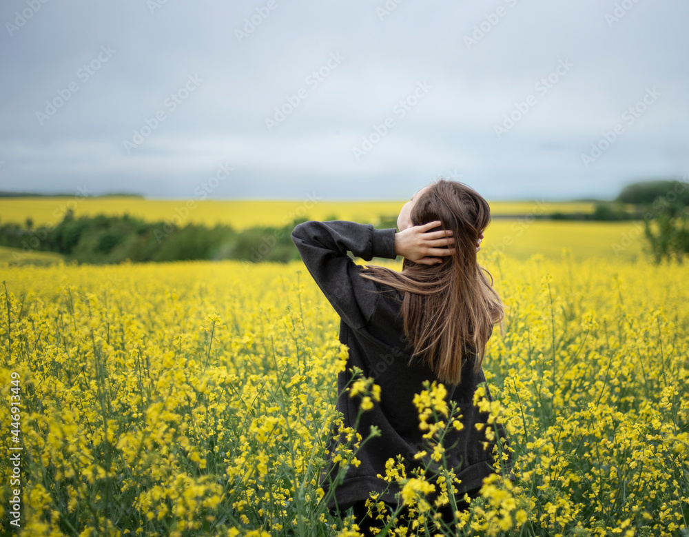 Fototapeta premium Young girl on yellow rapeseed field