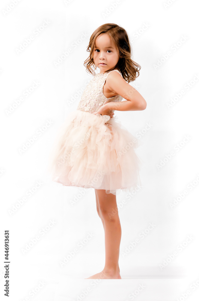 Portrait of happy pretty curly little girl standing and posing over white background