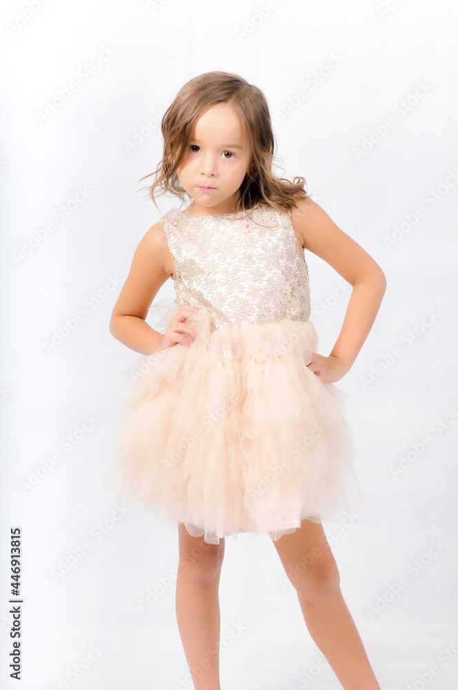 Portrait of happy pretty curly little girl standing and posing over white background