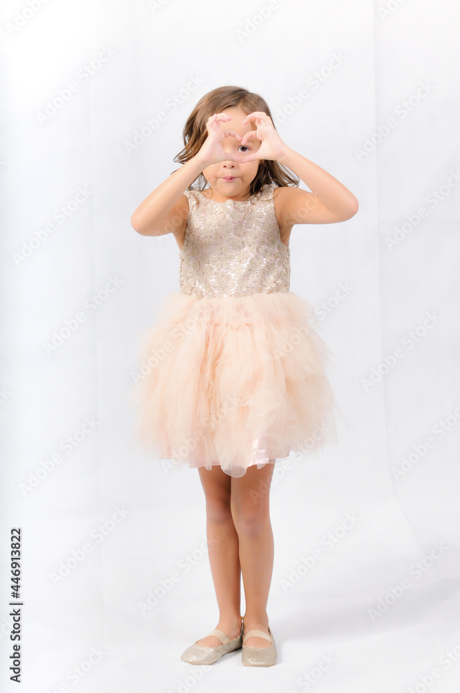 Naklejka premium Portrait of happy pretty curly little girl standing and posing over white background