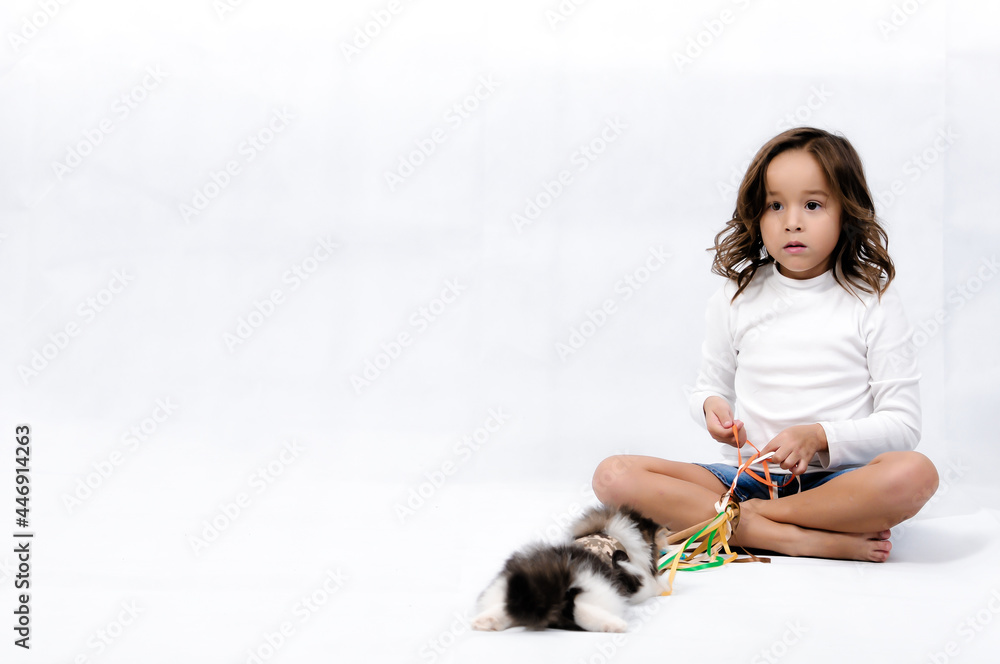 Portrait of happy pretty curly little girl sit on the floor and playing  toy stick over white background , play and fun conceptual 
