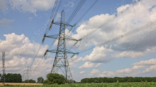 Electricity pylons in a field with clouds and blue sky time lapse. 4k Hertfordshire UK.  photo
