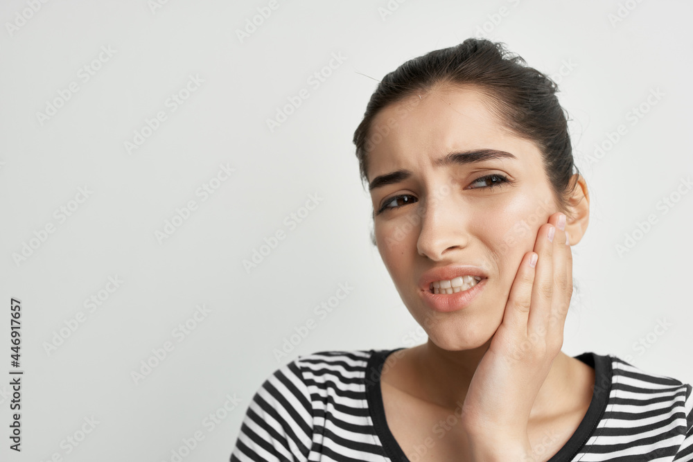 woman in striped t-shirt holding face toothache discontent woman in striped t-shirt holding face toothache discontent